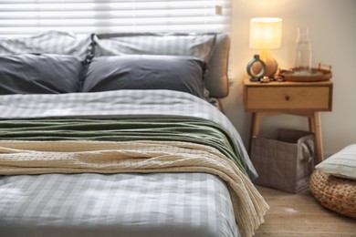 Photo of Comfortable bed with soft linens and blankets in room, closeup. Home textile