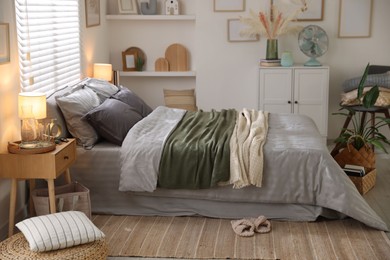 Photo of Comfortable bed with soft linens and blankets in room. Home textile