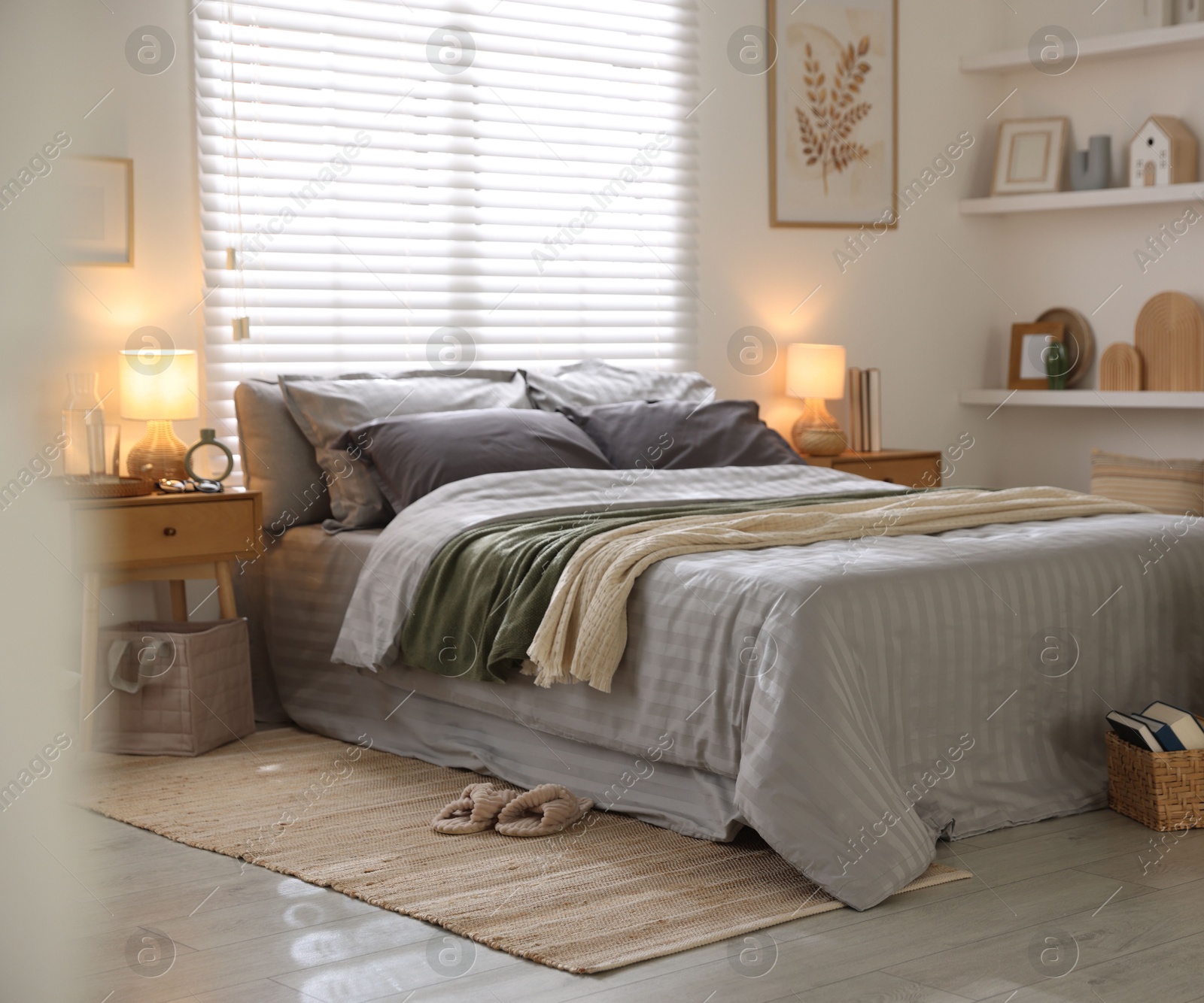 Comfortable bed with soft linens and blankets in room. Home textile Photo of Comfortable bed with soft linens and blankets in room. Home textile
