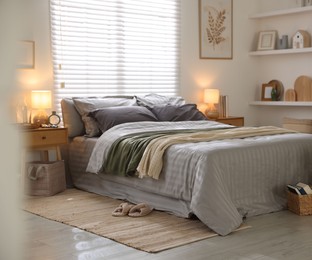 Photo of Comfortable bed with soft linens and blankets in room. Home textile