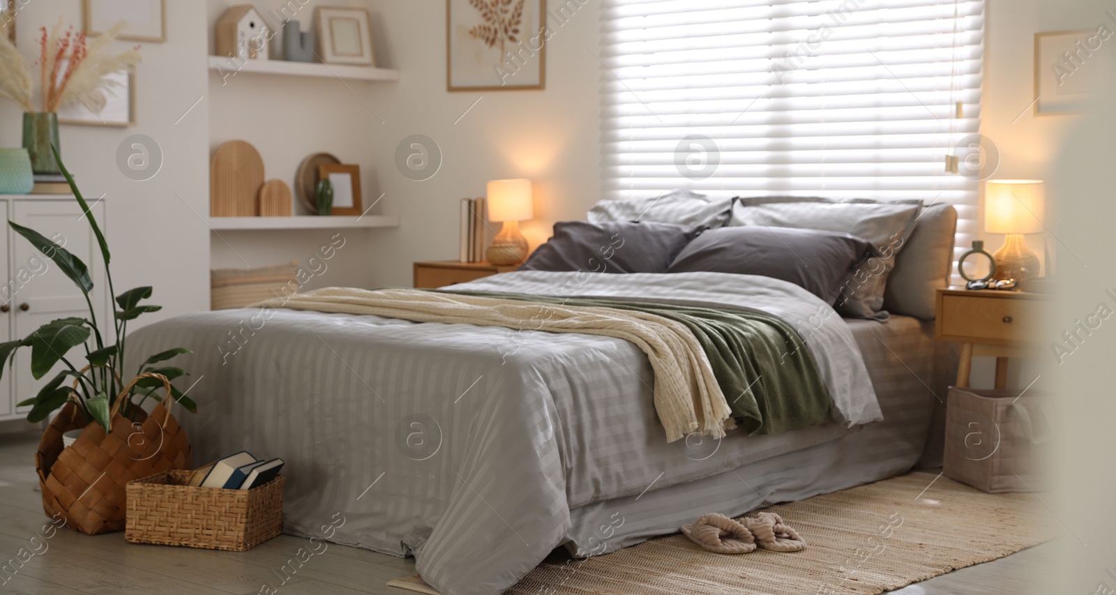 Comfortable bed with soft linens and blankets in room. Home textile Photo of Comfortable bed with soft linens and blankets in room. Home textile