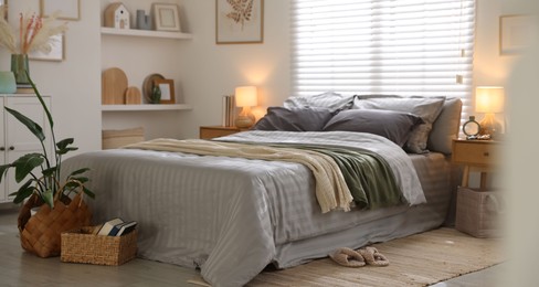 Photo of Comfortable bed with soft linens and blankets in room. Home textile