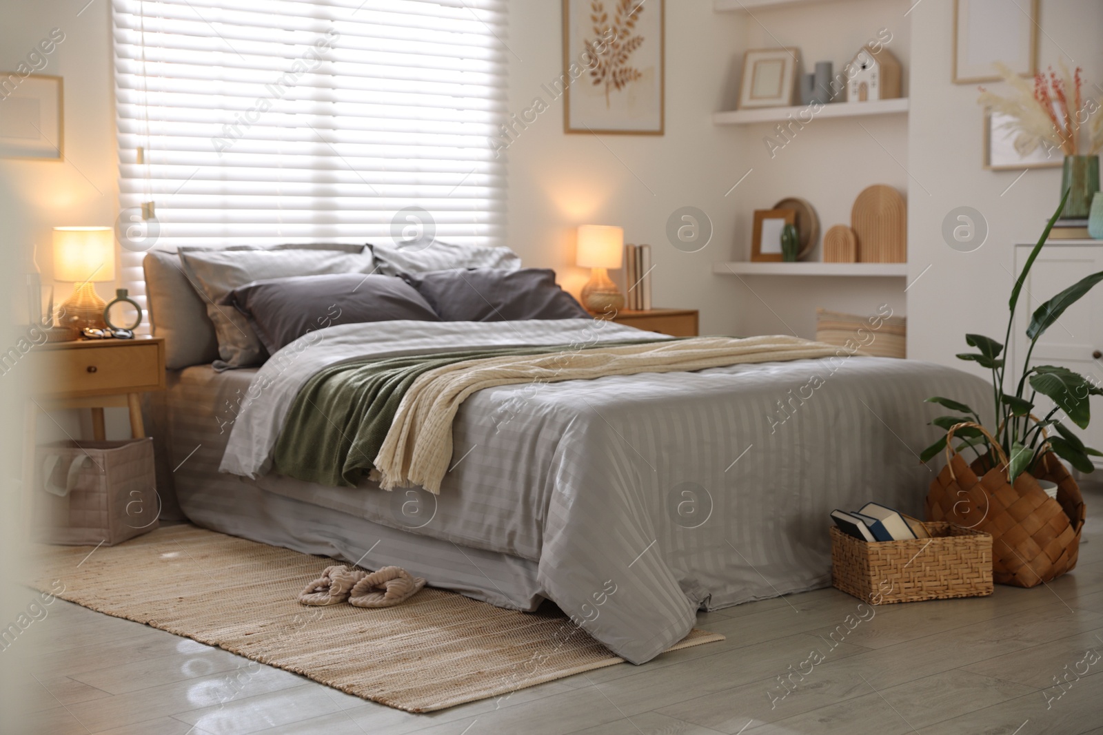 Comfortable bed with soft linens and blankets in room. Home textile Photo of Comfortable bed with soft linens and blankets in room. Home textile