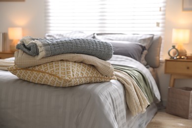 Photo of Comfortable bed with soft linens and blankets in room, closeup. Home textile