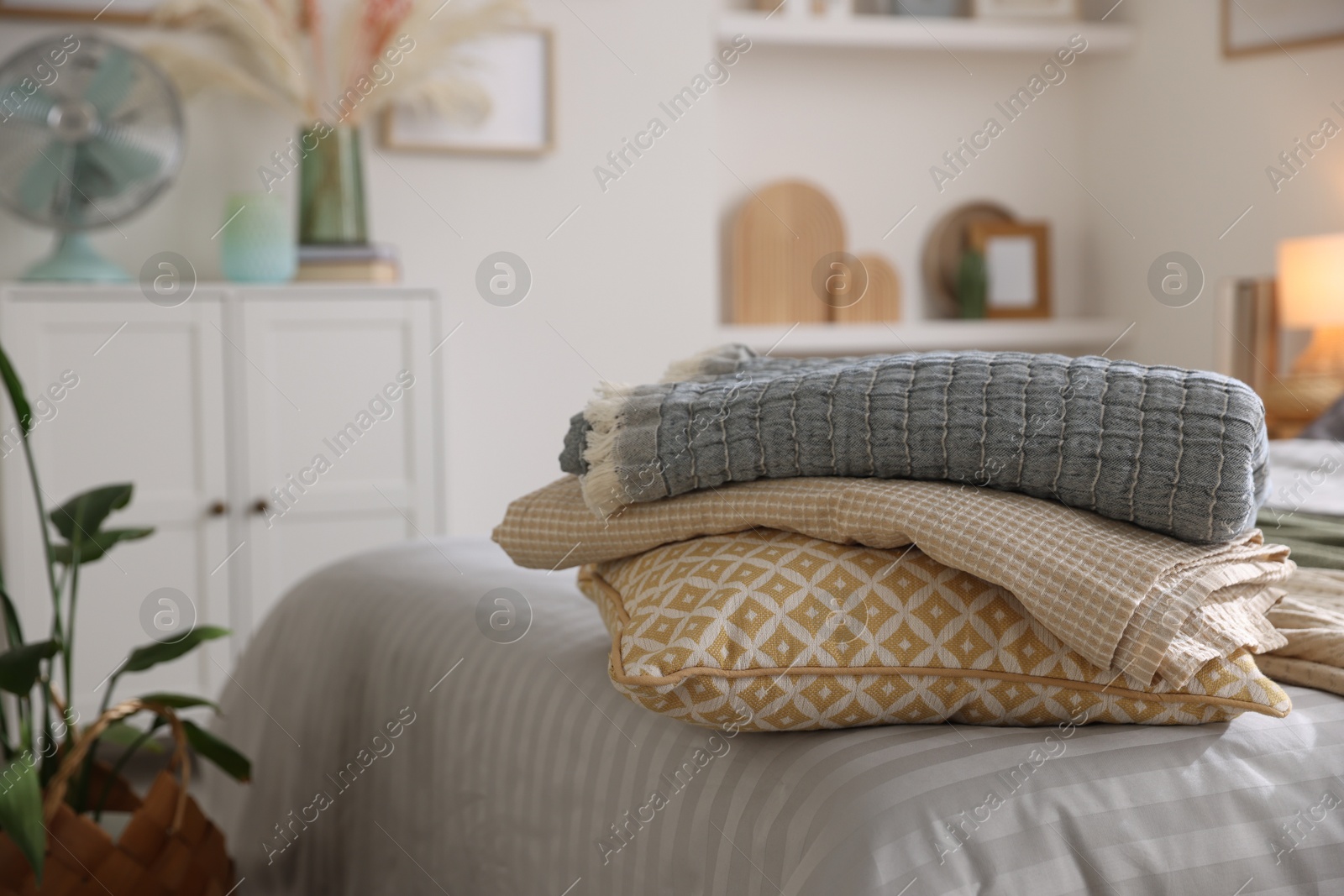 Comfortable bed with soft linens and blankets in room, closeup. Home textile Photo of Comfortable bed with soft linens and blankets in room, closeup. Home textile