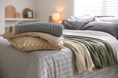 Photo of Comfortable bed with soft linens and blankets in room, closeup. Home textile