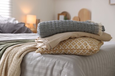 Photo of Comfortable bed with soft linens and blankets in room, closeup. Home textile