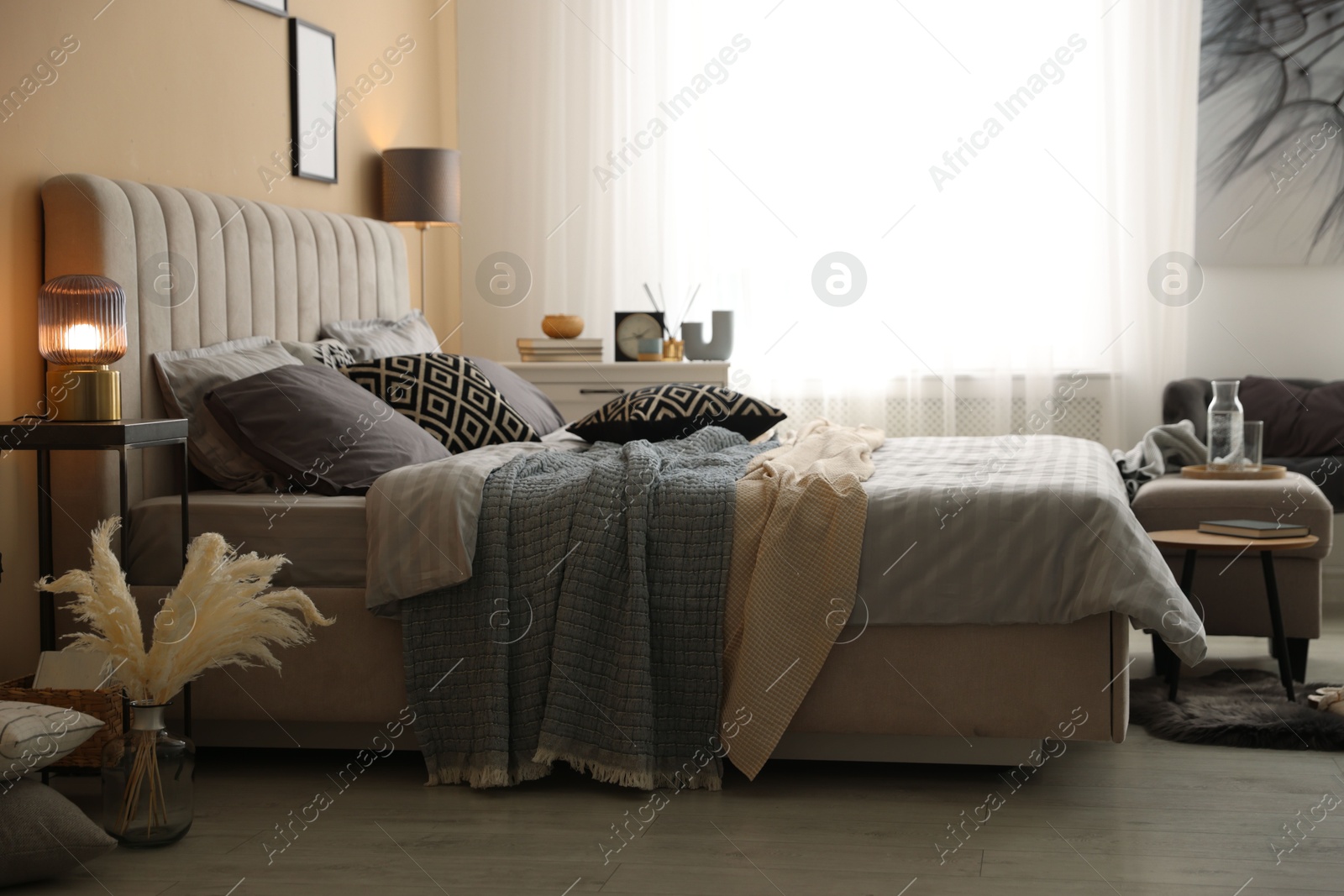 Comfortable bed with soft linens and blankets in room. Home textile Photo of Comfortable bed with soft linens and blankets in room. Home textile