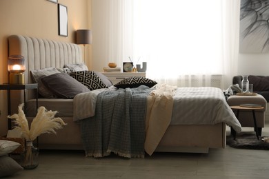 Photo of Comfortable bed with soft linens and blankets in room. Home textile