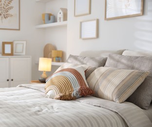 Photo of Comfortable bed with soft linens in room, closeup. Home textile