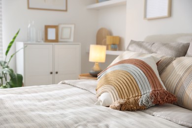 Photo of Comfortable bed with soft linens in room, closeup. Home textile