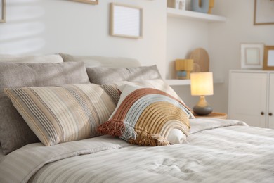 Photo of Comfortable bed with soft linens in room, closeup. Home textile