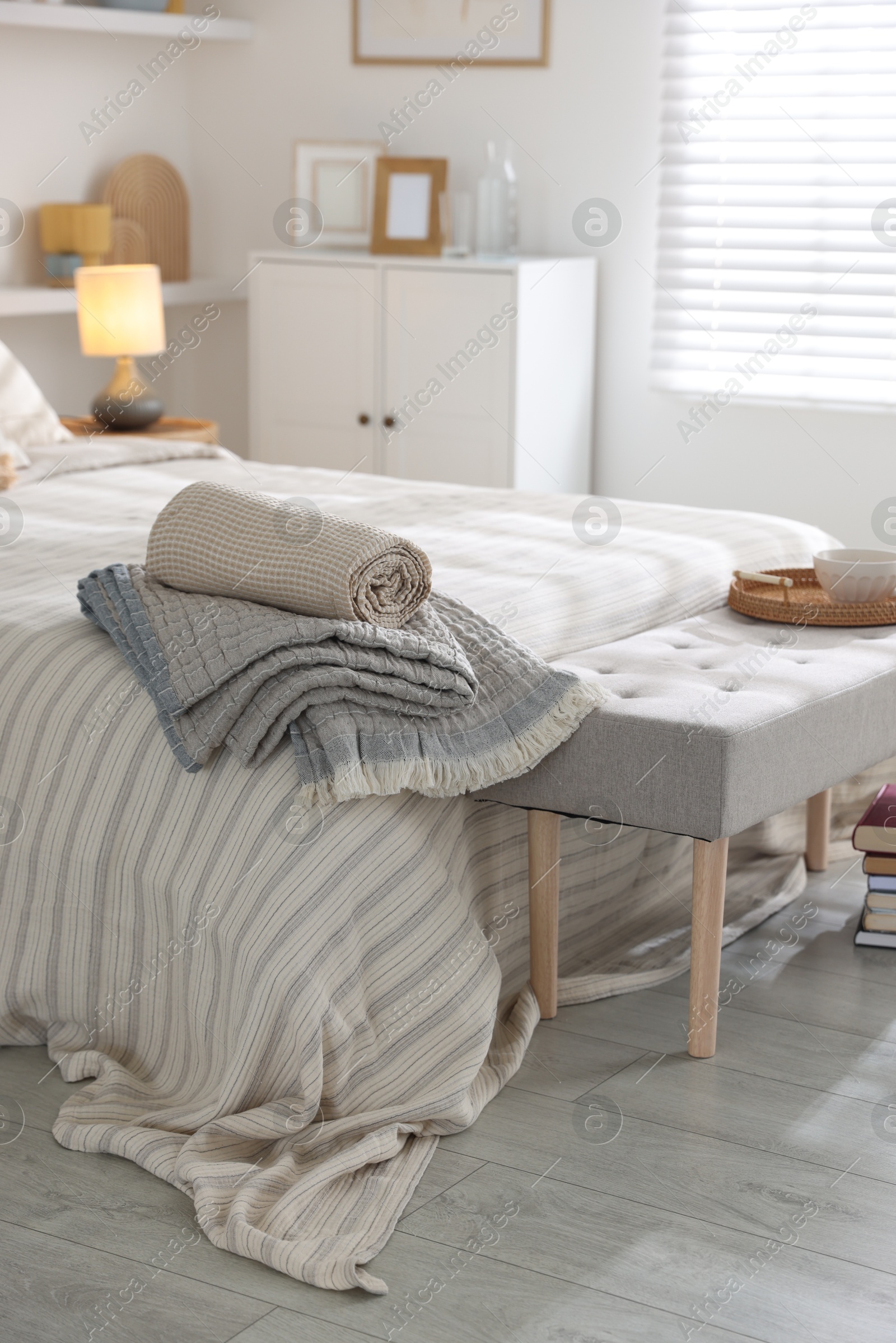 Comfortable bed with soft linens in room. Home textile Photo of Comfortable bed with soft linens in room. Home textile