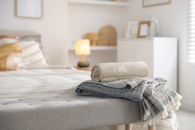 Photo of Comfortable bed with soft linens and blankets in room, closeup. Home textile