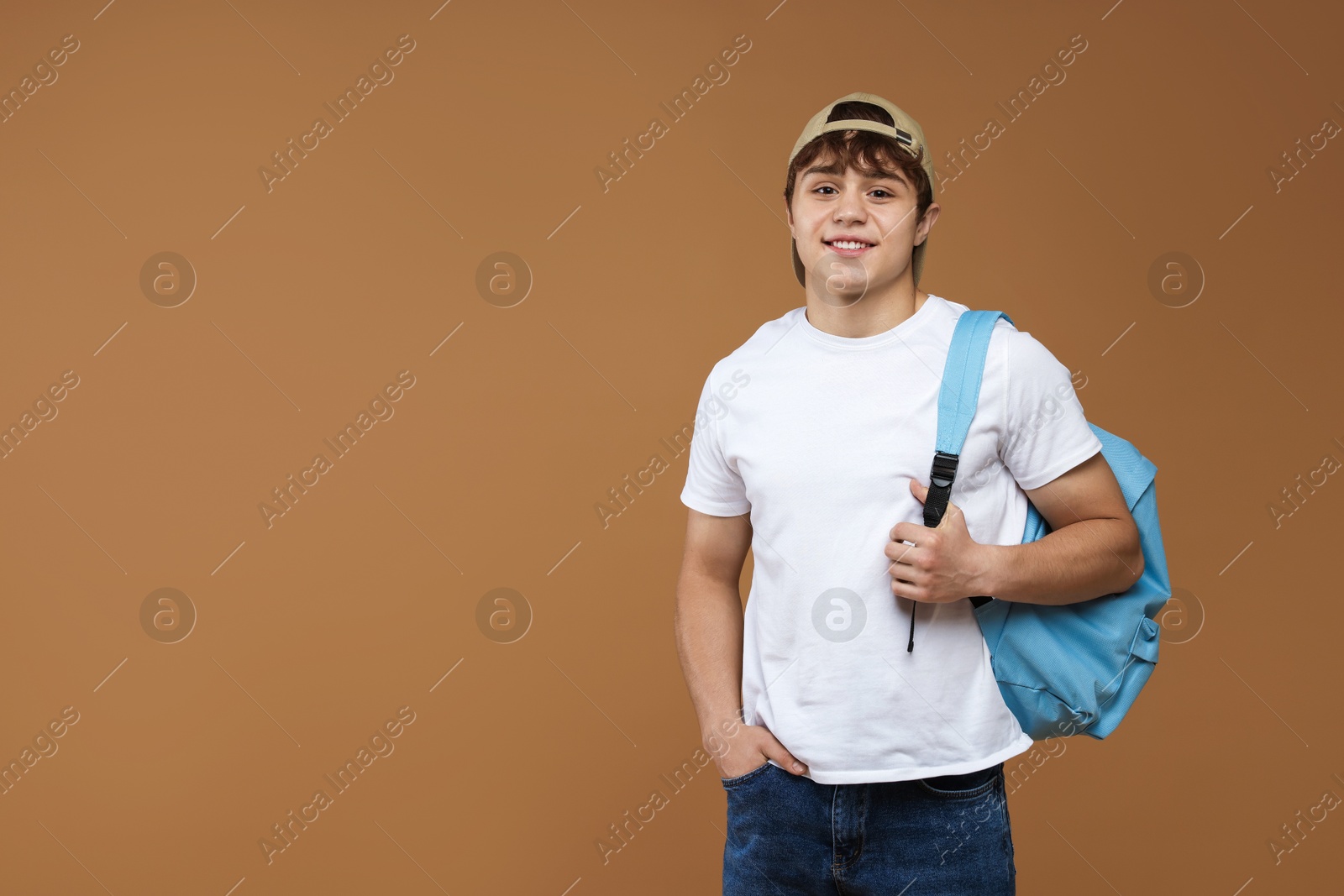 Teenage boy with backpack on brown background. Space for text Photo of Teenage boy with backpack on brown background. Space for text