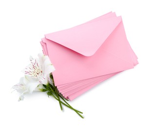 Photo of Stack of love letters and flowers isolated on white, top view