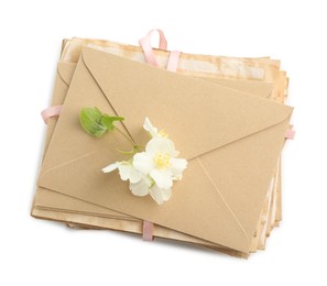 Photo of Stack of love letters and flowers isolated on white, top view