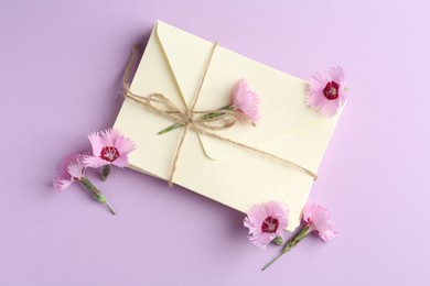Photo of Stack of love letters and carnation flowers on violet background, flat lay