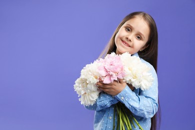 Photo of Cute little girl with bouquet of beautiful peonies on purple background, space for text