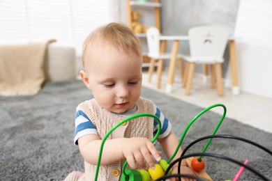 Photo of Cute little baby playing with toy in room