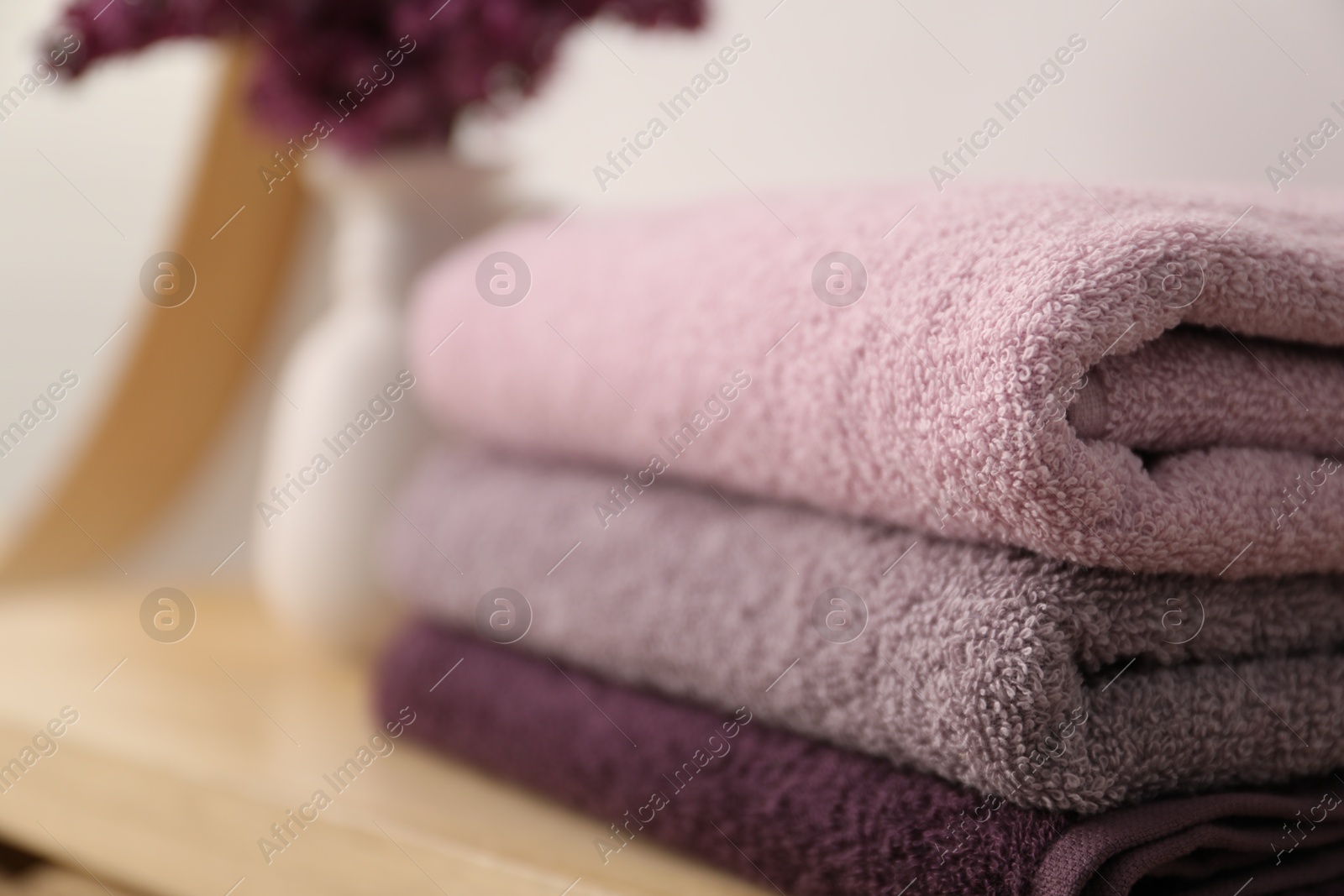 Stack of soft towels on table indoors, closeup. Space for text Photo of Stack of soft towels on table indoors, closeup. Space for text