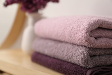 Photo of Stack of soft towels on table indoors, closeup. Space for text