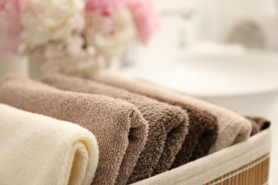 Photo of Soft towels in storage basket indoors, closeup