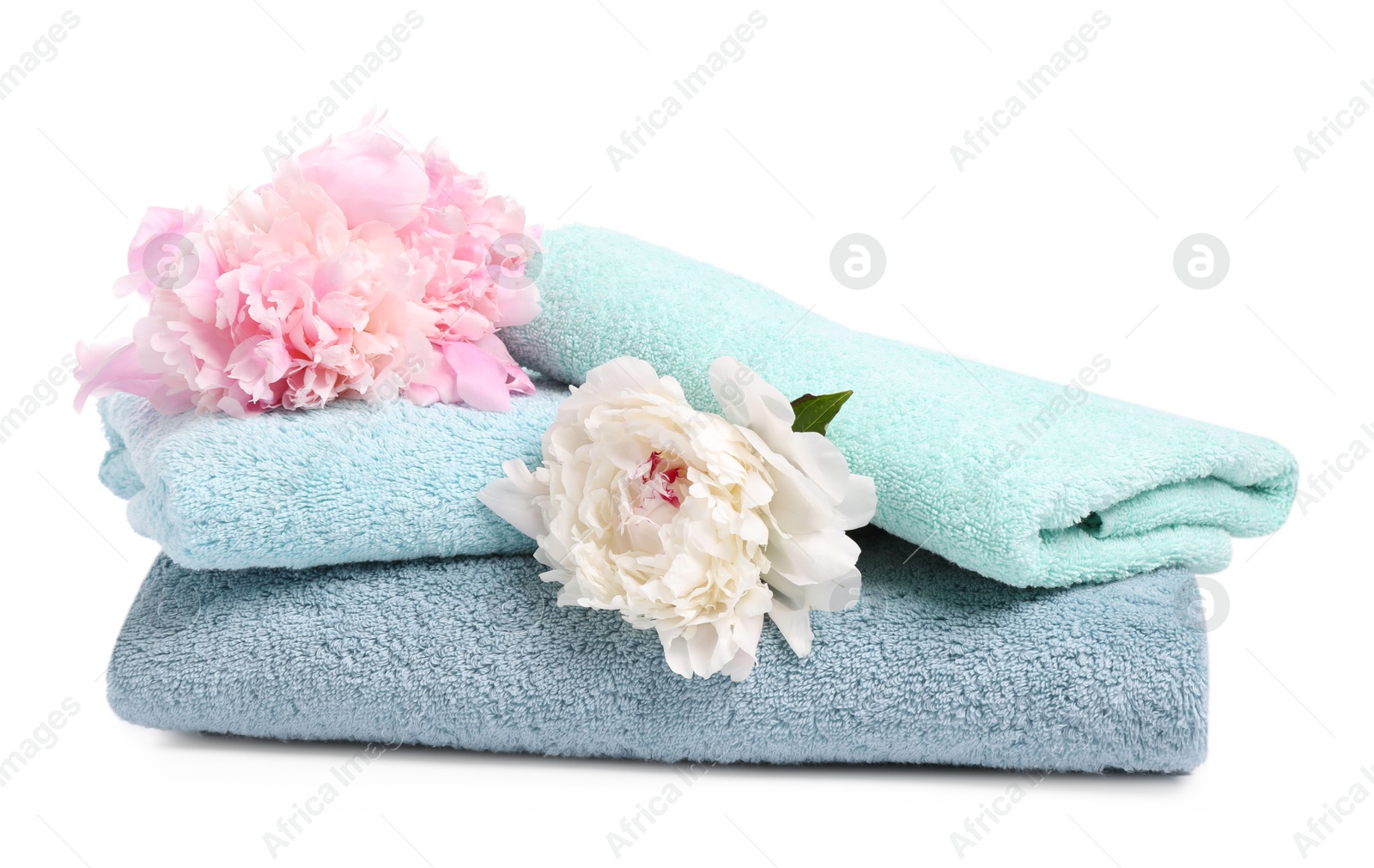 Soft towels and peony flowers isolated on white Photo of Soft towels and peony flowers isolated on white