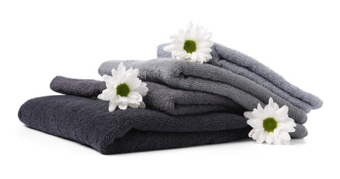 Photo of Stack of soft towels and chrysanthemum flowers isolated on white