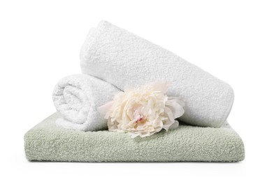 Photo of Stack of soft towels and peony flower isolated on white