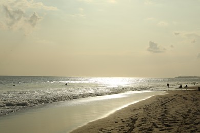Photo of Beautiful view of sea and people relaxing on sandy beach