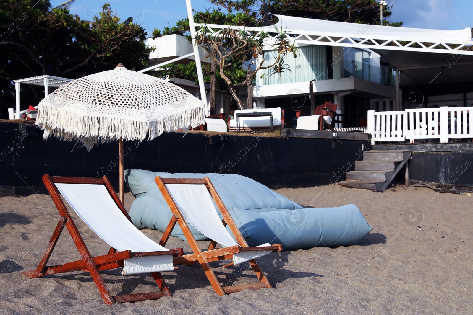 Wooden deck chairs and beach umbrella at resort Photo of Wooden deck chairs and beach umbrella at resort