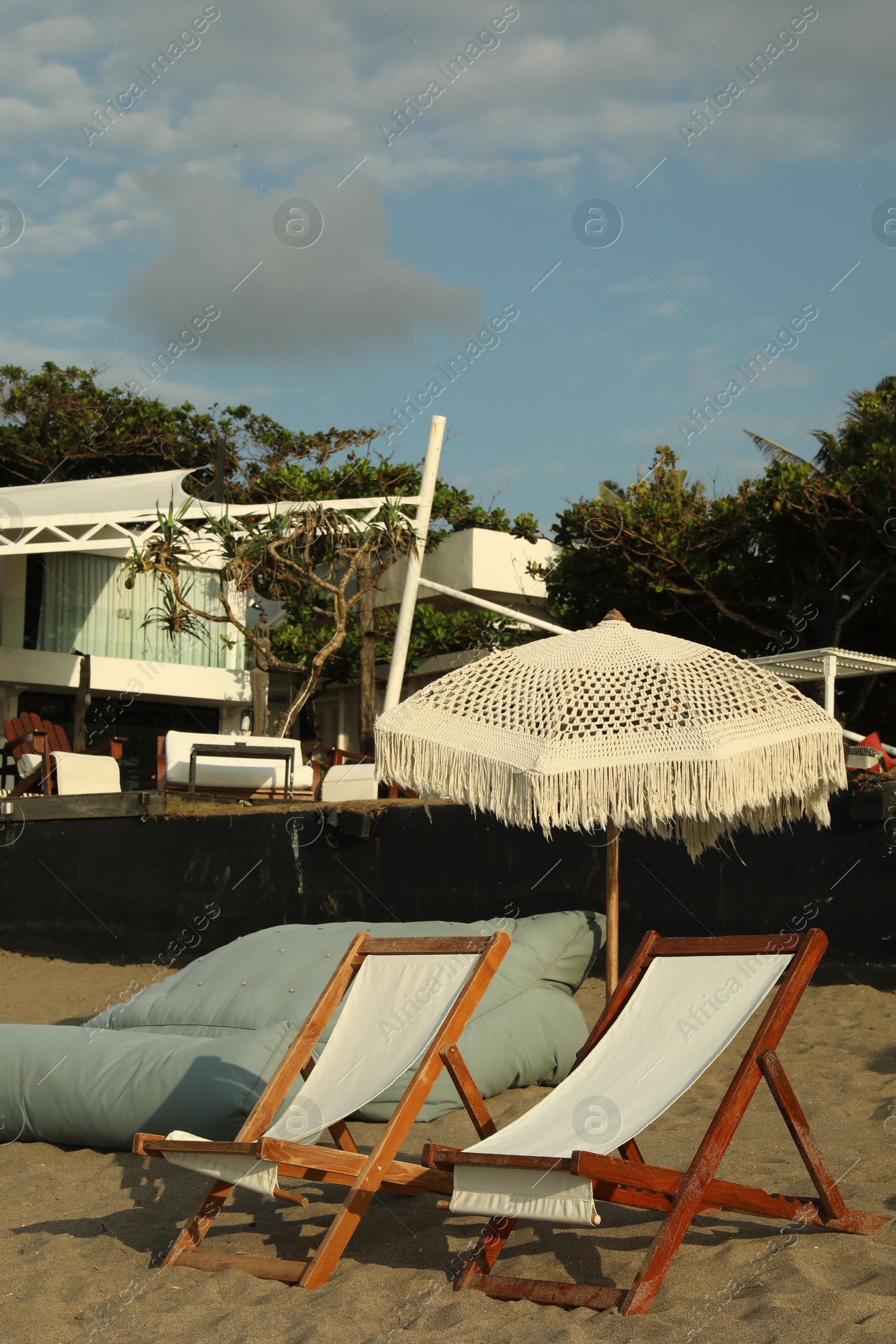 Wooden deck chairs and beach umbrella at resort Photo of Wooden deck chairs and beach umbrella at resort
