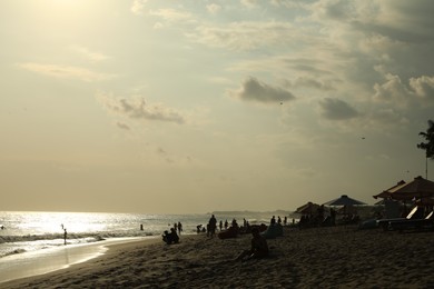 Photo of People relaxing on sandy beach by sea
