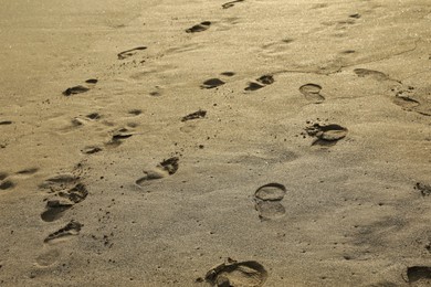 Photo of Many different footprints on sand as background