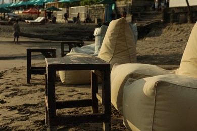 Photo of Bali, Indonesia - May 20, 2025: Beanbags and wooden tables on beach