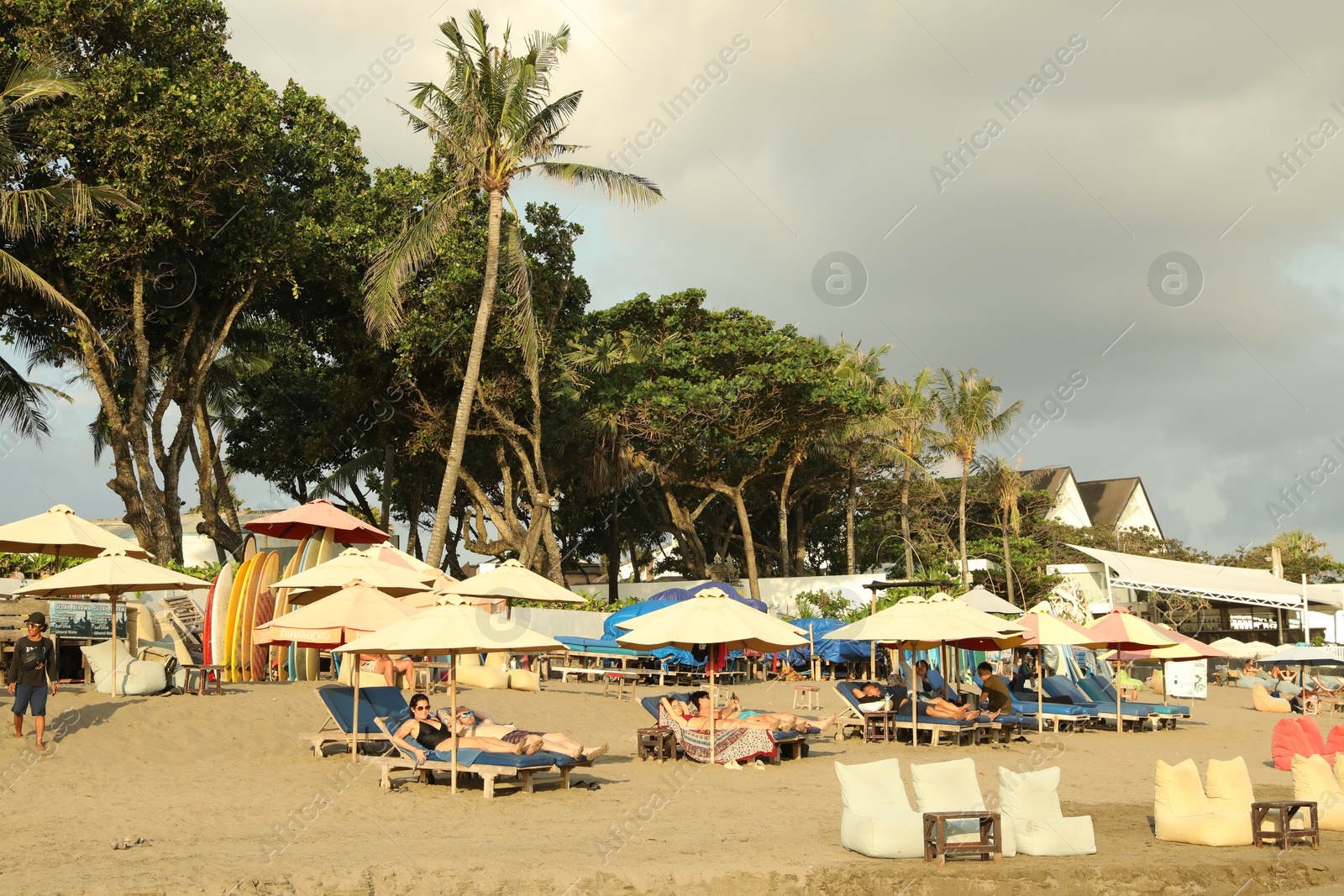 Bali, Indonesia - May 20, 2025: People relaxing on sun loungers at resort Photo of Bali, Indonesia - May 20, 2025: People relaxing on sun loungers at resort