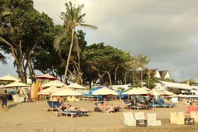 Photo of Bali, Indonesia - May 20, 2025: People relaxing on sun loungers at resort