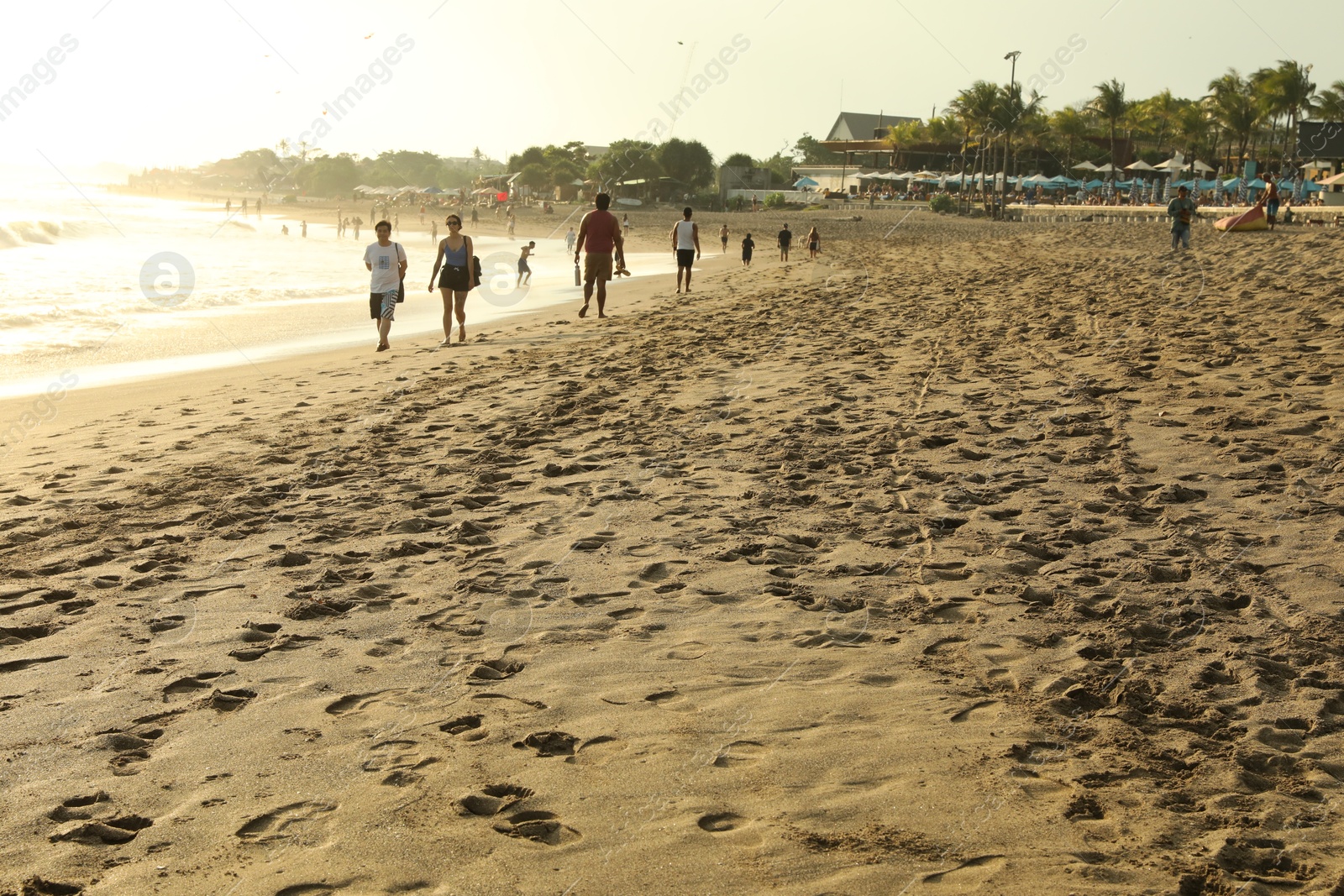 Bali, Indonesia - May 20, 2025: People walking along seashore Photo of Bali, Indonesia - May 20, 2025: People walking along seashore