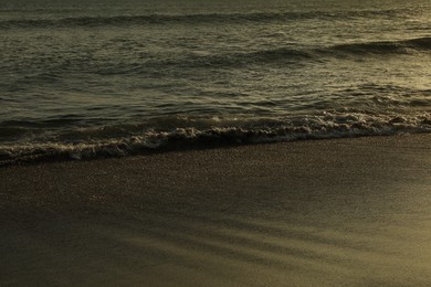 Photo of Beautiful wavy sea and wet sandy beach at sunrise