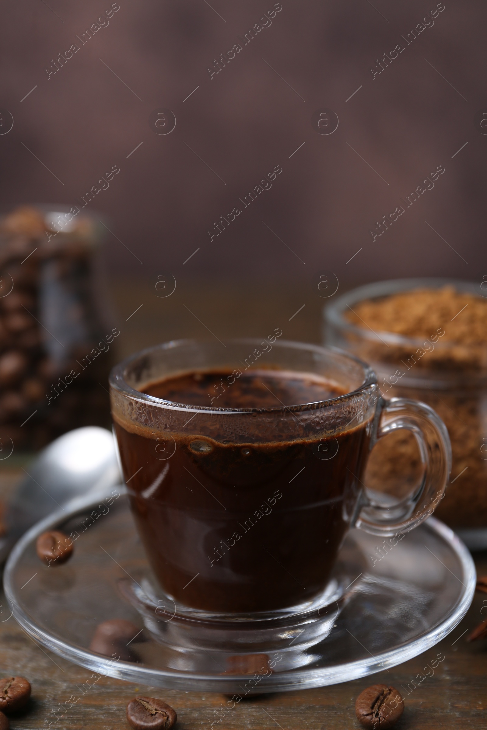 Cup of aromatic coffee, beans, instant powder and spices on wooden table, closeup Photo of Cup of aromatic coffee, beans, instant powder and spices on wooden table, closeup