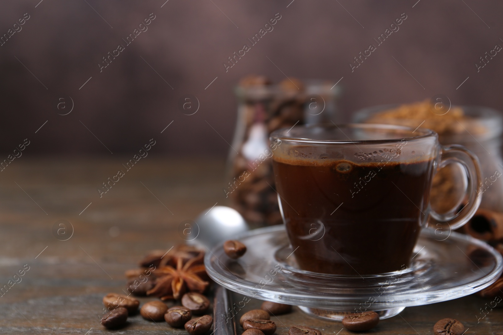 Cup of aromatic coffee, beans, instant powder and spices on wooden table, closeup. Space for text Photo of Cup of aromatic coffee, beans, instant powder and spices on wooden table, closeup. Space for text