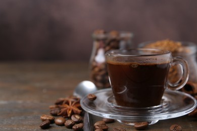 Photo of Cup of aromatic coffee, beans, instant powder and spices on wooden table, closeup. Space for text