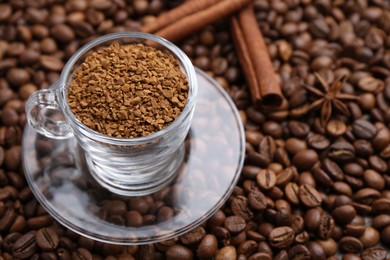 Photo of Cup with granulated instant coffee and cinnamon on beans, closeup. Space for text