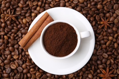 Photo of Cup with instant coffee powder and cinnamon on beans, top view
