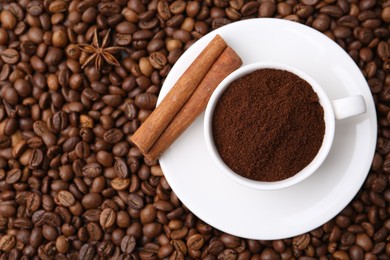 Photo of Cup with instant coffee powder and cinnamon on beans, top view. Space for text