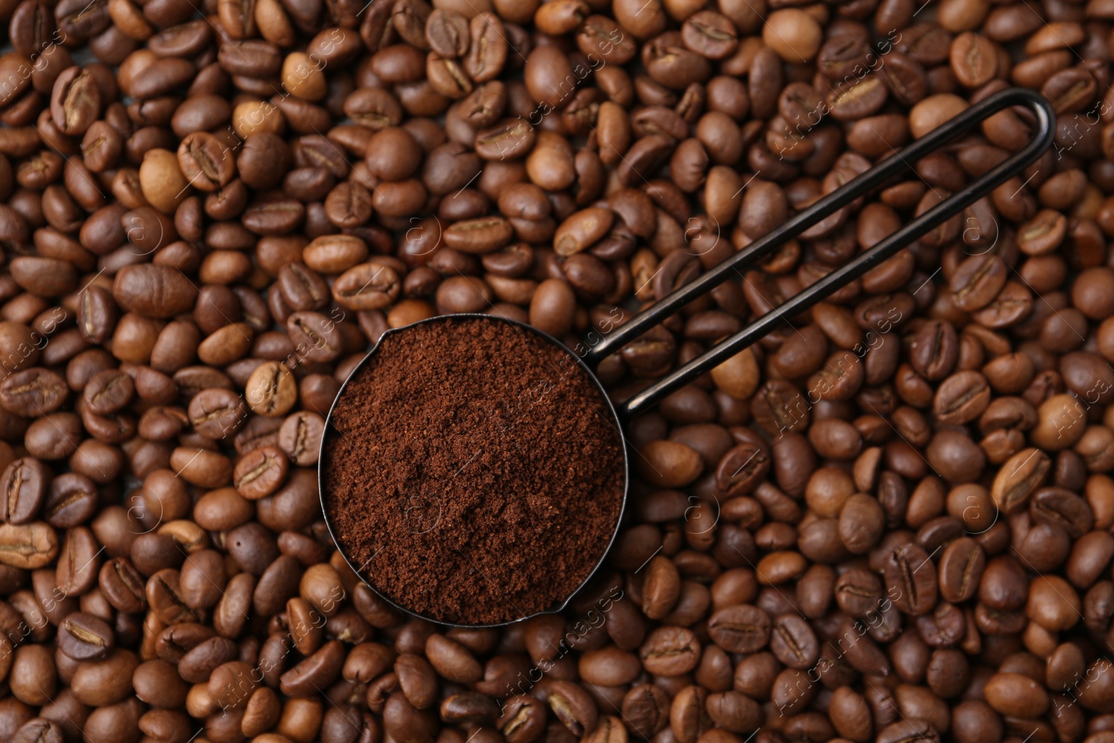 Scoop with instant coffee powder on beans, top view Photo of Scoop with instant coffee powder on beans, top view