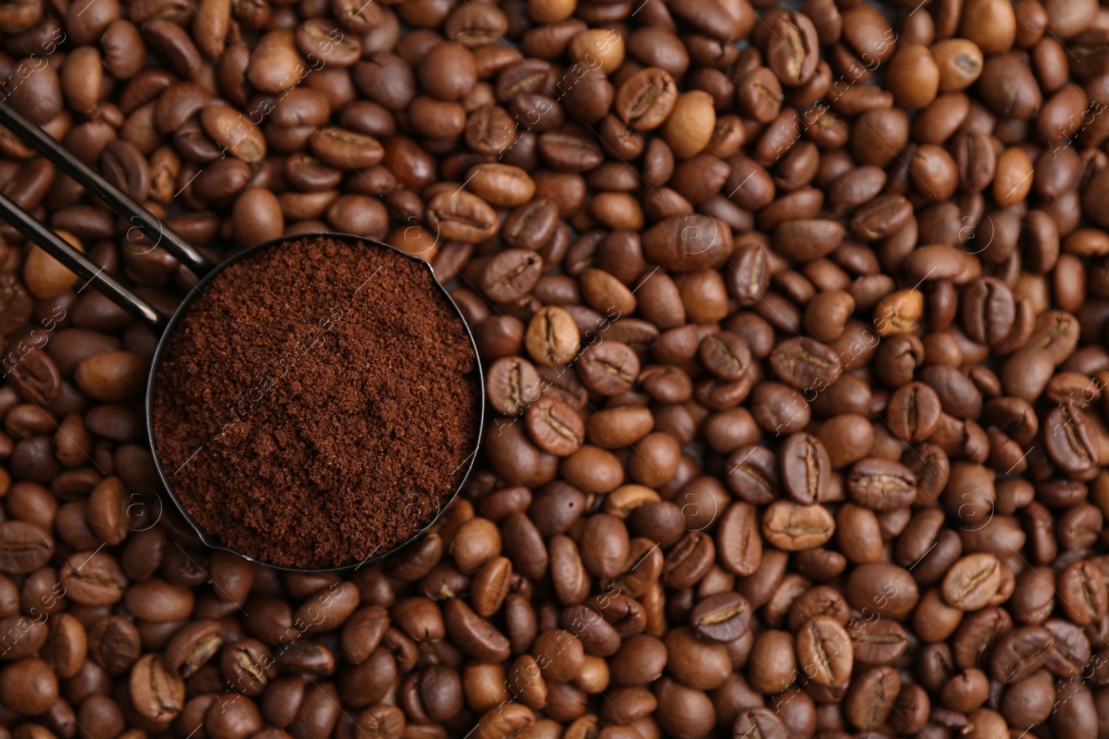 Scoop with instant coffee powder on beans, top view Photo of Scoop with instant coffee powder on beans, top view
