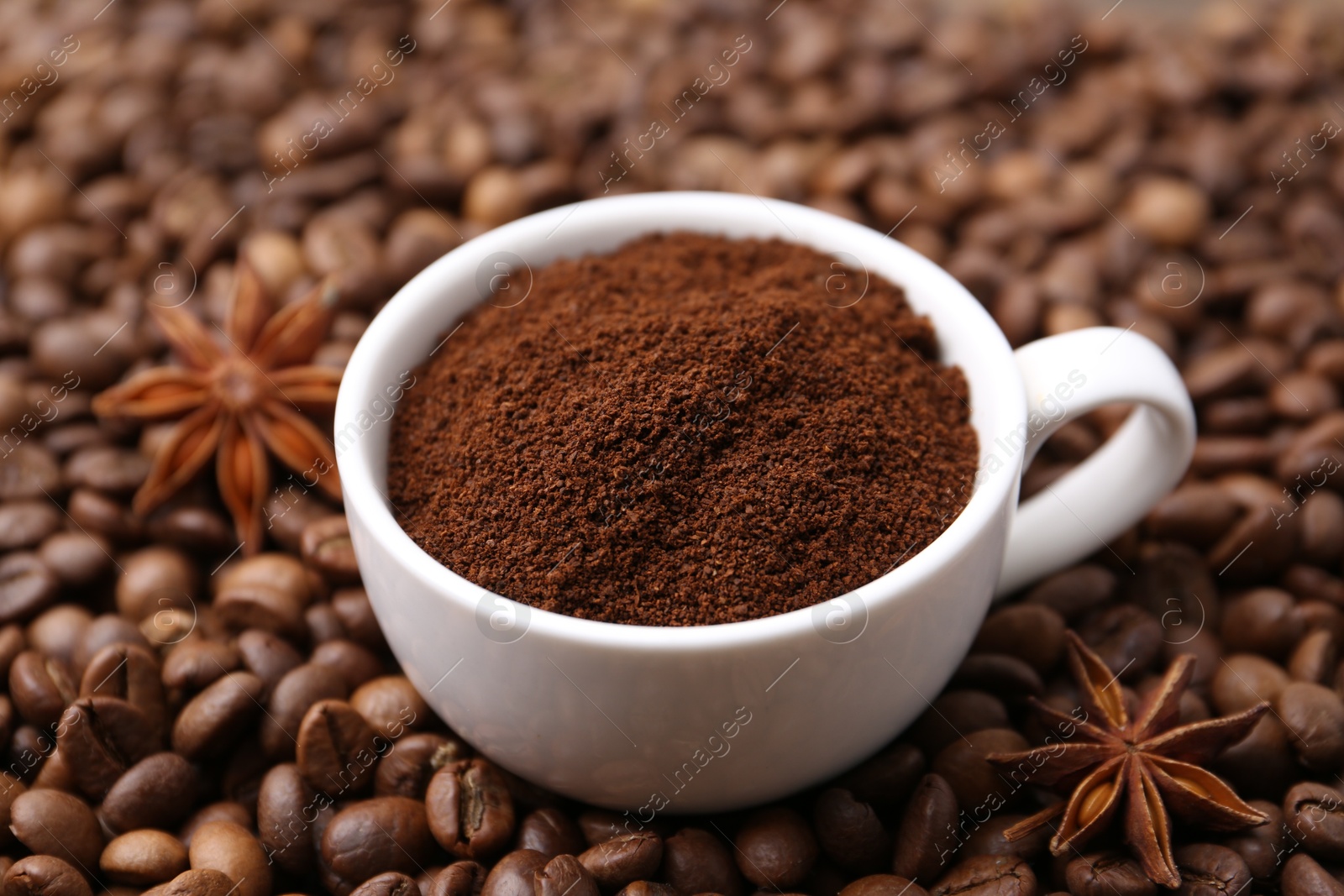 Cup with instant coffee powder and star anise on beans, closeup Photo of Cup with instant coffee powder and star anise on beans, closeup
