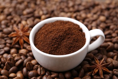 Photo of Cup with instant coffee powder and star anise on beans, closeup